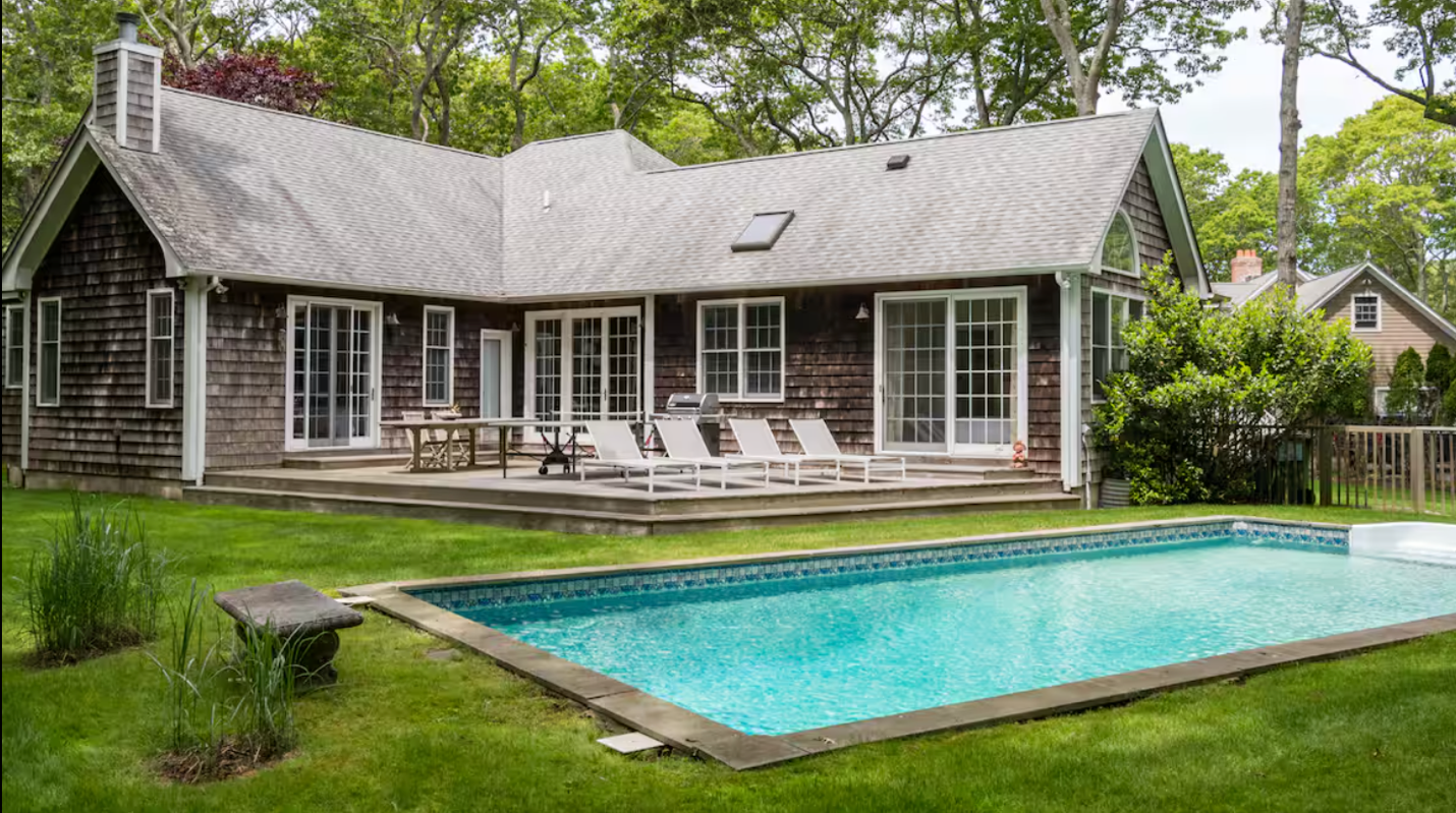 A house with a pool in the back
Description automatically generated